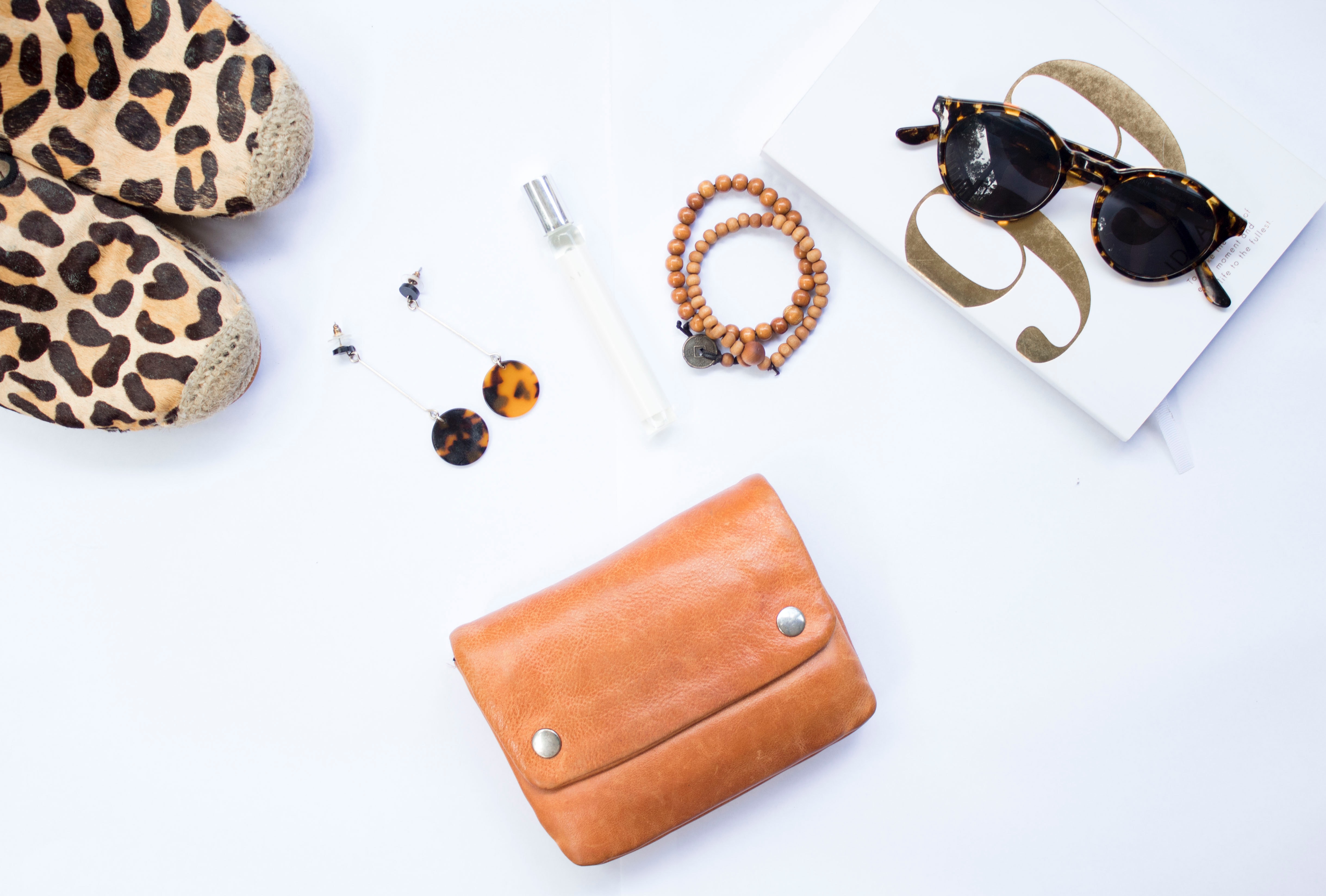 purse, shoes, sunglasses on a white surface